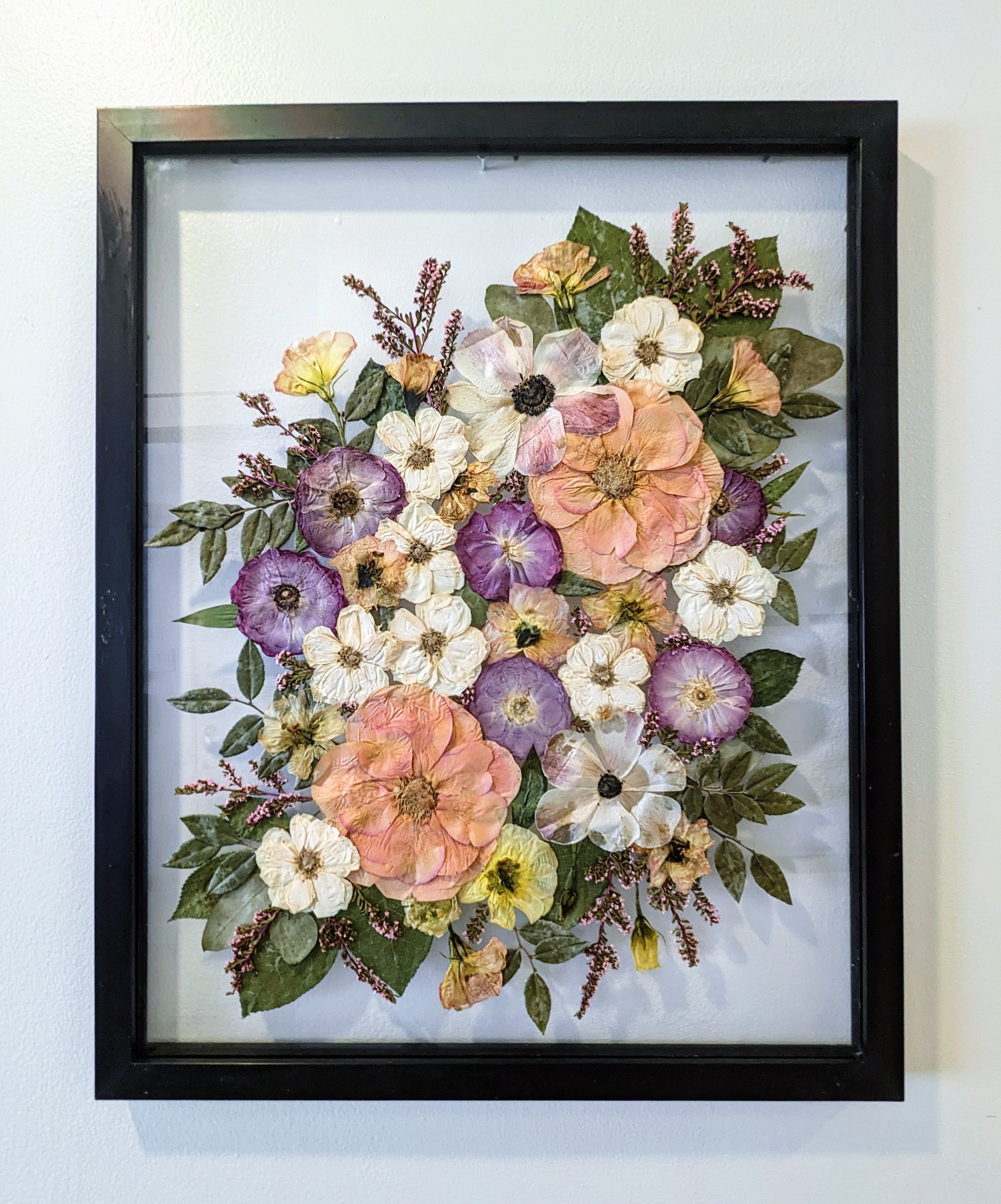 Colorful botanical artwork with pressed flowers arranged in a geometric pattern.