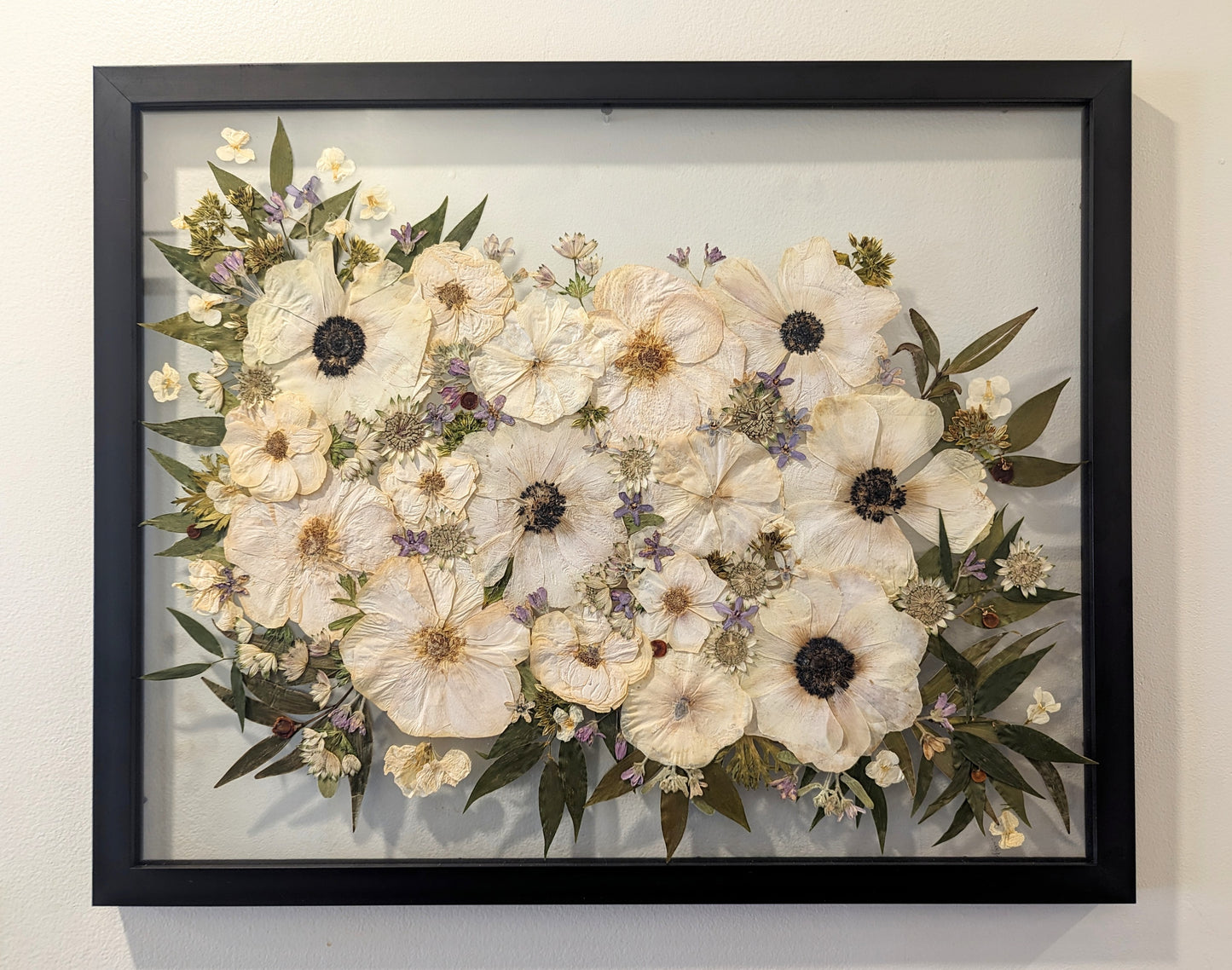 Colorful botanical artwork with pressed flowers arranged in a geometric pattern.