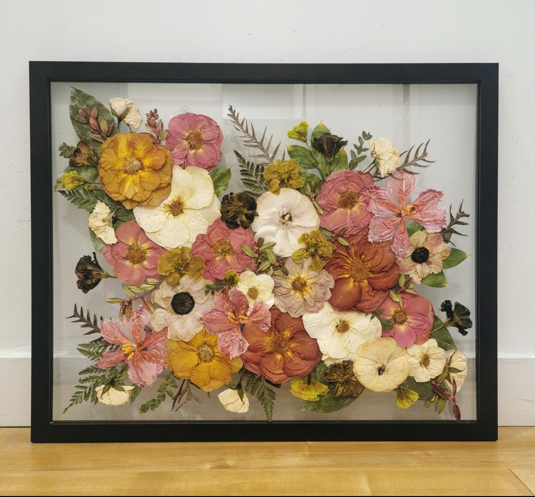 Colorful botanical artwork with pressed flowers arranged in a geometric pattern.