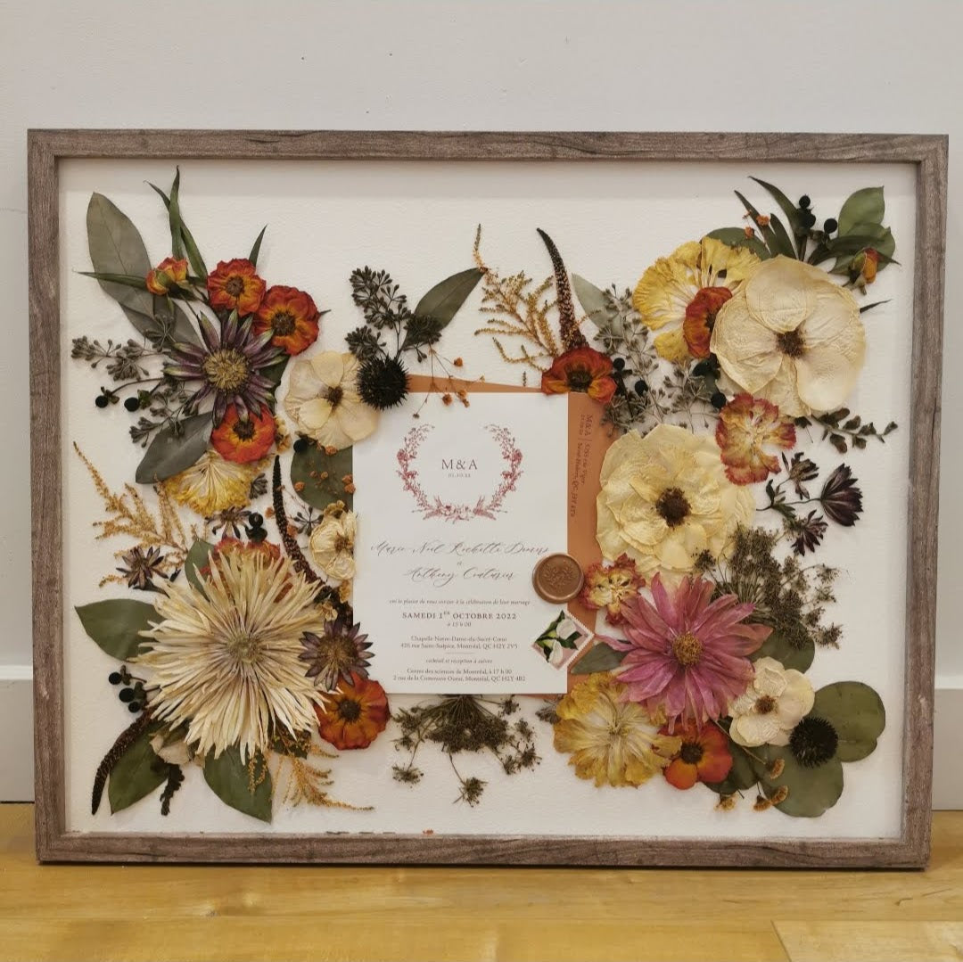 Pressed flower artwork with intricate floral patterns in a wooden frame.