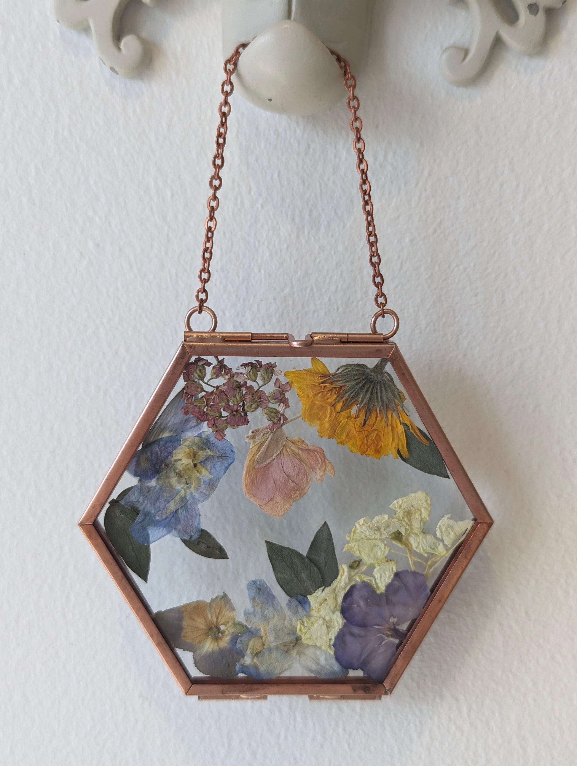 Handcrafted wedding keepsake featuring pressed flowers in a vintage frame.