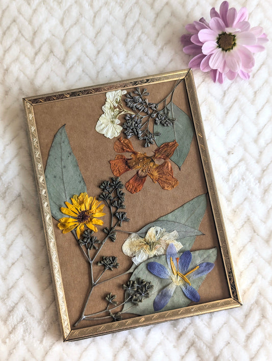 Floral art piece showcasing pressed sunflowers arranged in a vintage frame.