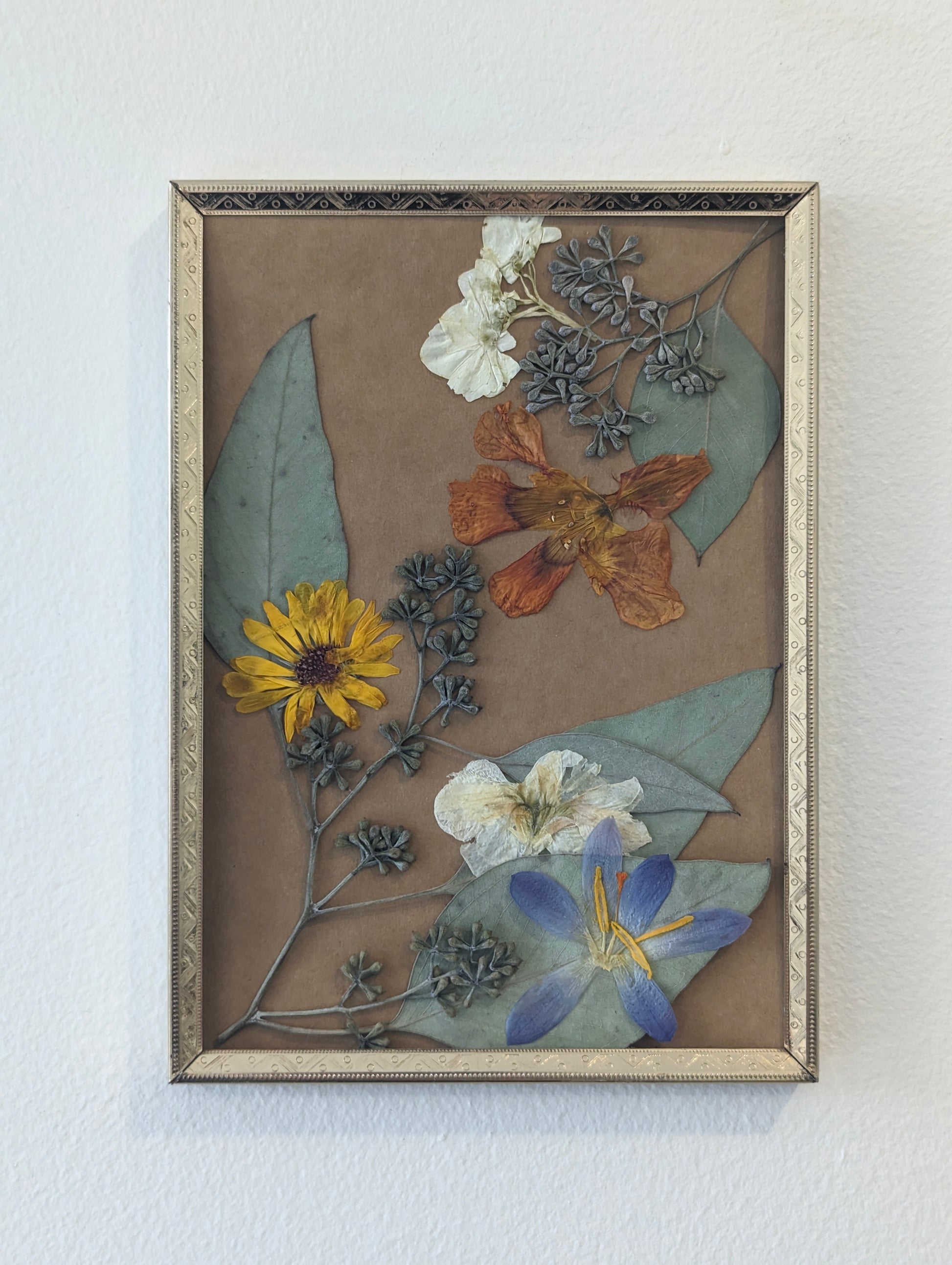 Floral art piece showcasing pressed sunflowers arranged in a vintage frame.