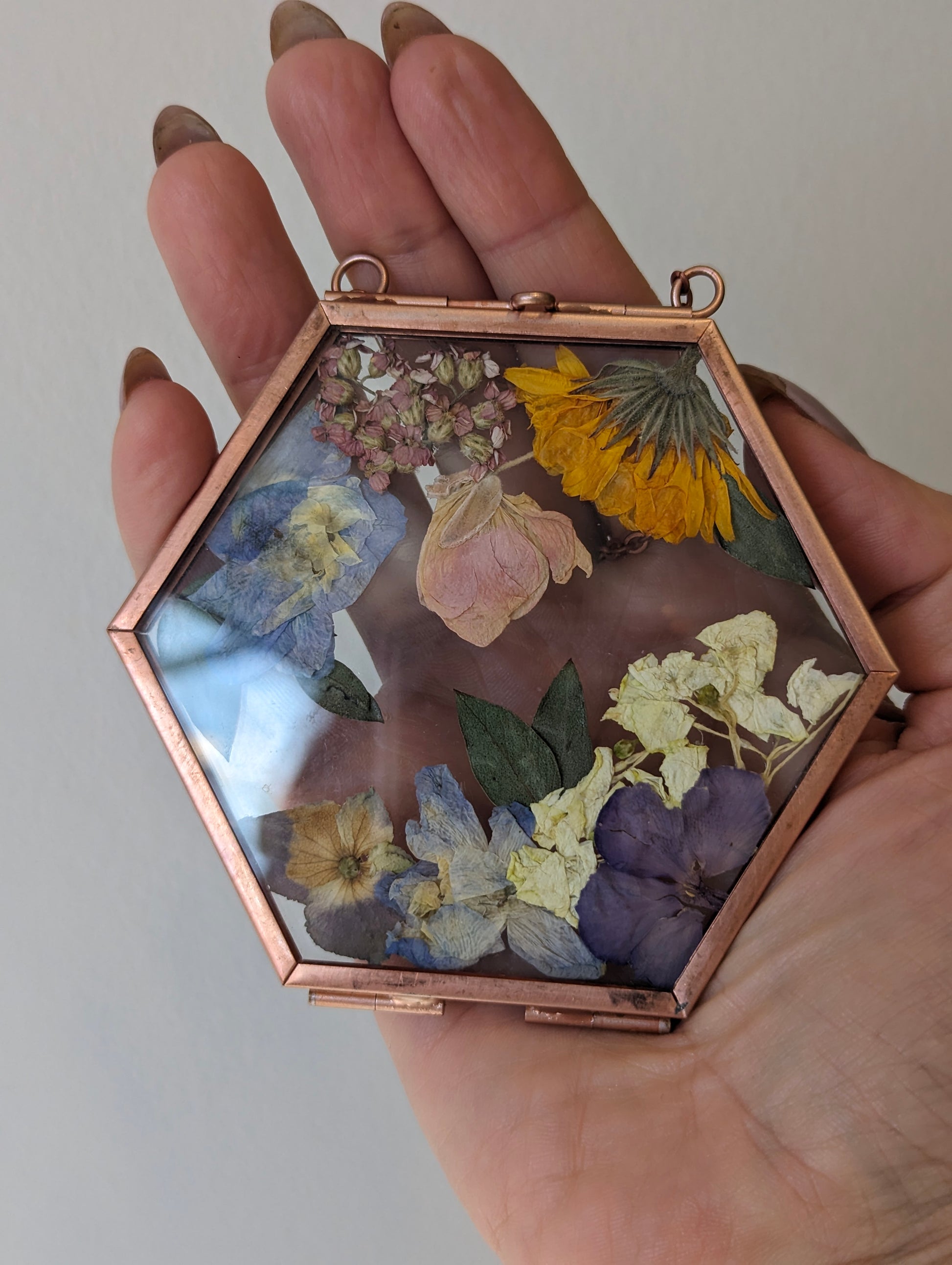 Handcrafted wedding keepsake featuring pressed flowers in a vintage frame.